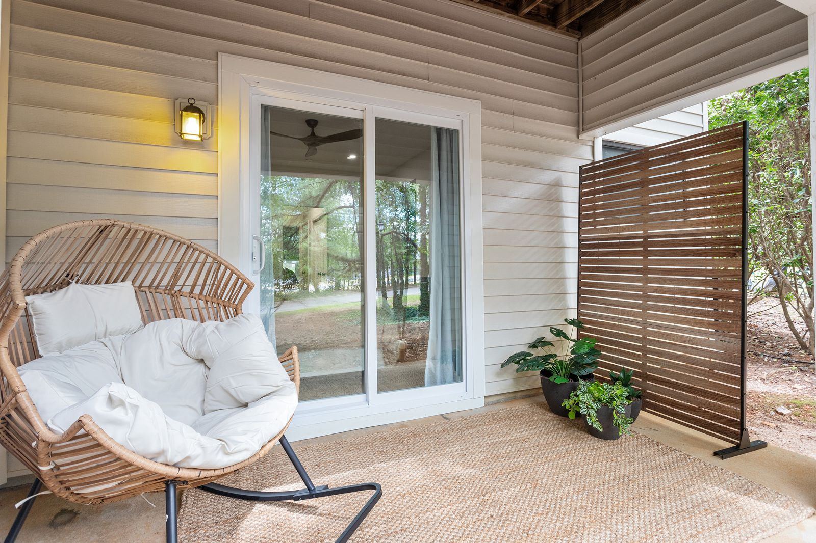 Private patio with a cushioned lounge chair and privacy screen