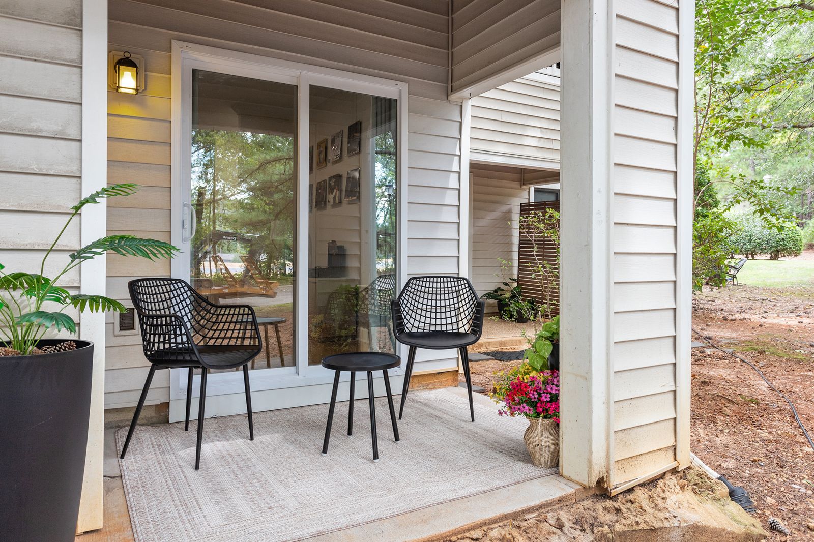 Private covered patio with two chairs and a side table