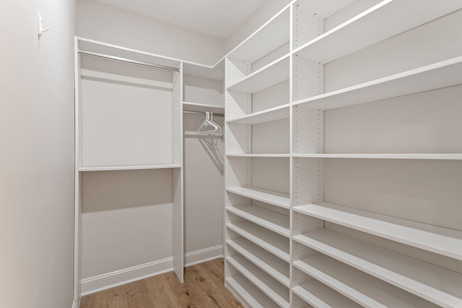 Walk-in closet with hanging rails and floor-to-ceiling shelves